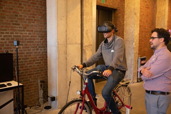 personen proberen fiets met VR-bril uit