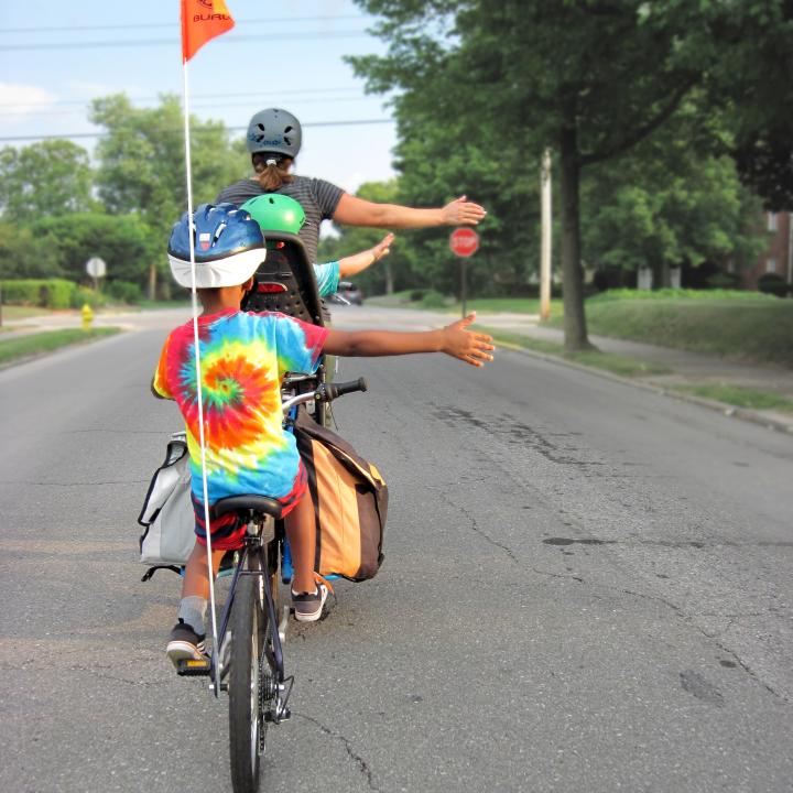 Gezin op fiets met helm en vlag